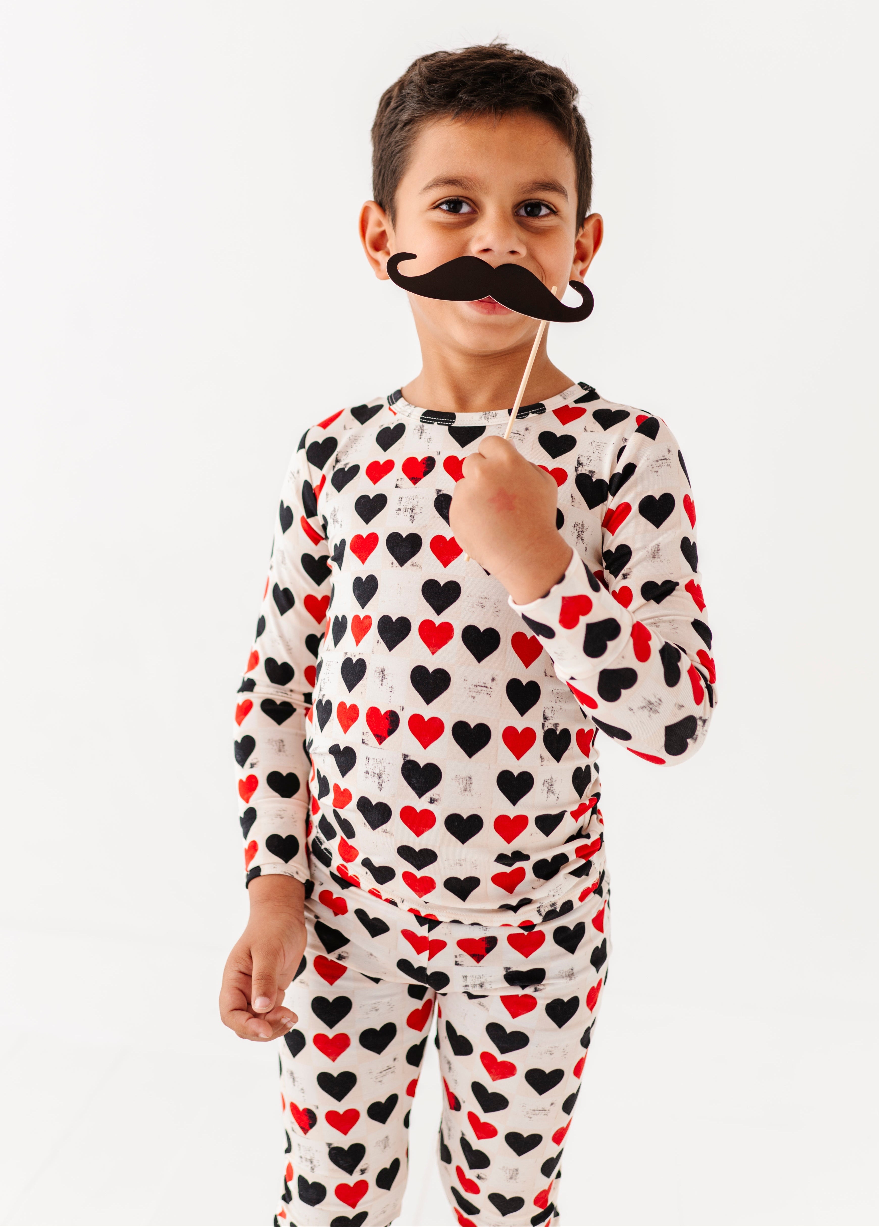 Child wearing King of Hearts bamboo pajama set with red and black heart print